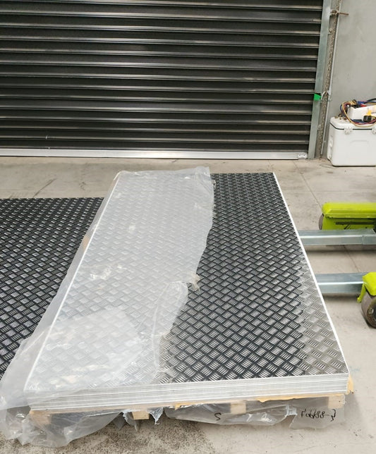 5052 Alloy Aluminium Checker Plate stored in a warehouse, showcasing its protective packaging and highlighting the detailed checkered design.