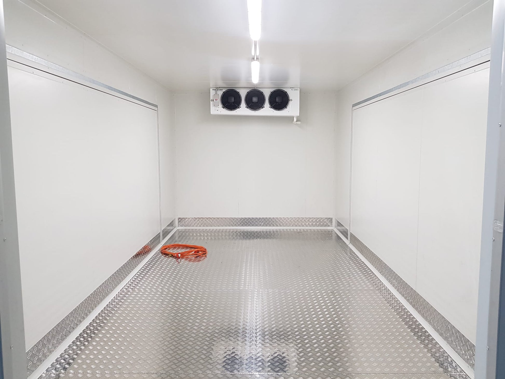A pristine interior of a cooled truck showcasing aluminium checker plate flooring with its distinct diamond pattern. The aluminium checker plate covers the entire floor, highlighting its resilience and durability.